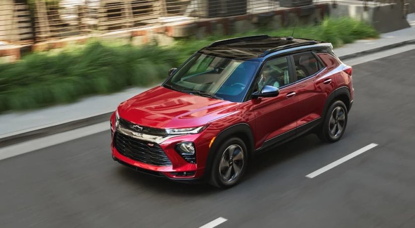 A red 2021 Chevy Trailblazer is shown from the side as it drives through a city.