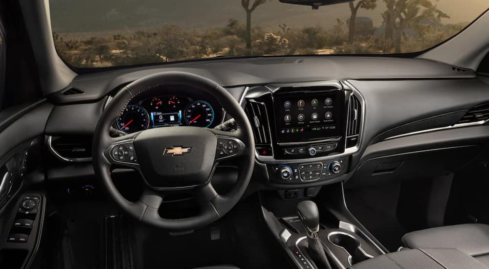 The interior of a 2021 Chevy Traverse shows the steering wheel and infotainment screen.