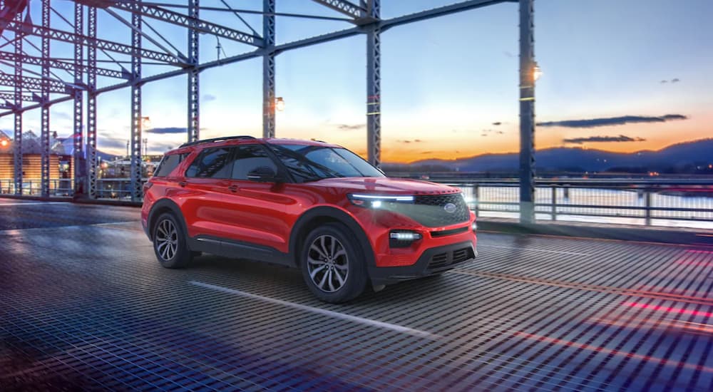 A red 2021 Ford Explorer is driving over a bridge.