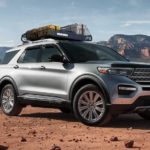 A silver 2021 Ford Explorer is parked in a desert with a roof rack.