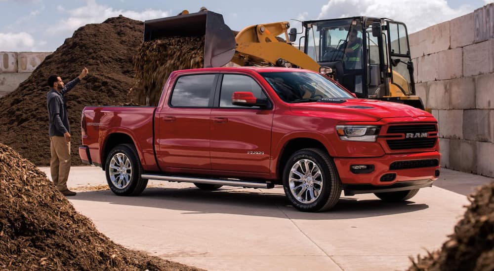 A red 2021 Ram 1500 is being used at a construction site.