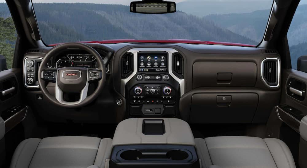 The interior of a 2021 GMC Sierra 2500 shows the steering wheel and infotainment screen.