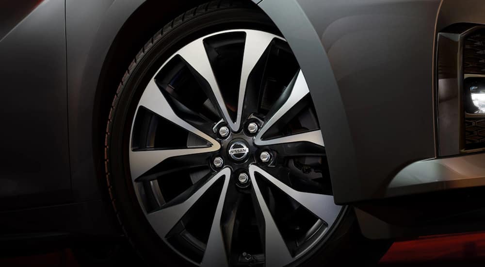 A close up of a silver 2021 Nissan Maxima shows a Nissan tire.
