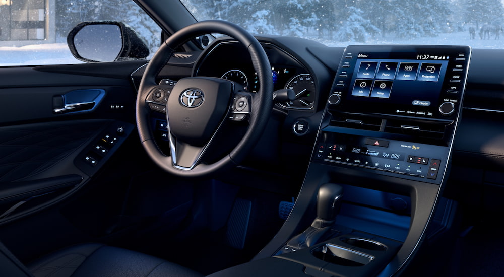 The interior of a 2021 Toyota Avalon shows the steering wheel and infotainment screen.