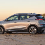 A silver 2022 Chevy Bolt EUV is parked on the beach at sunset.