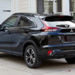 A black 2022 Eclipse Cross is parked in a driveway outside of a house.