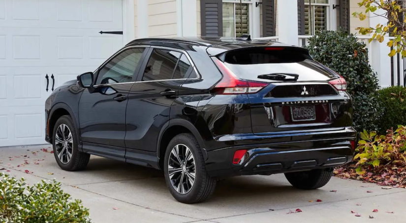 A black 2022 Eclipse Cross is parked in a driveway outside of a house.