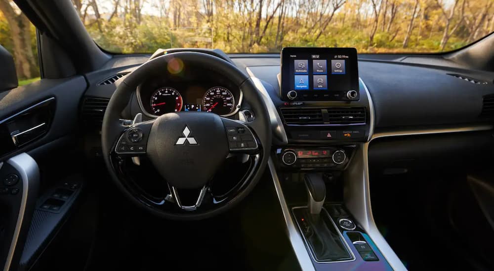 The interior of a 2022 Mitsubishi Eclipse Cross shows the steering wheel and infotainment screen.