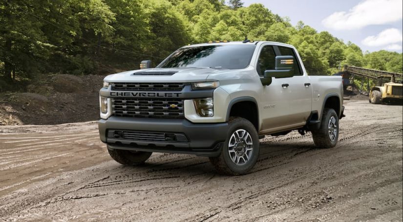 A Certified Pre-Owned Chevy white 2020 Chevrolet Silverado 2500HD is parked at a construction site.