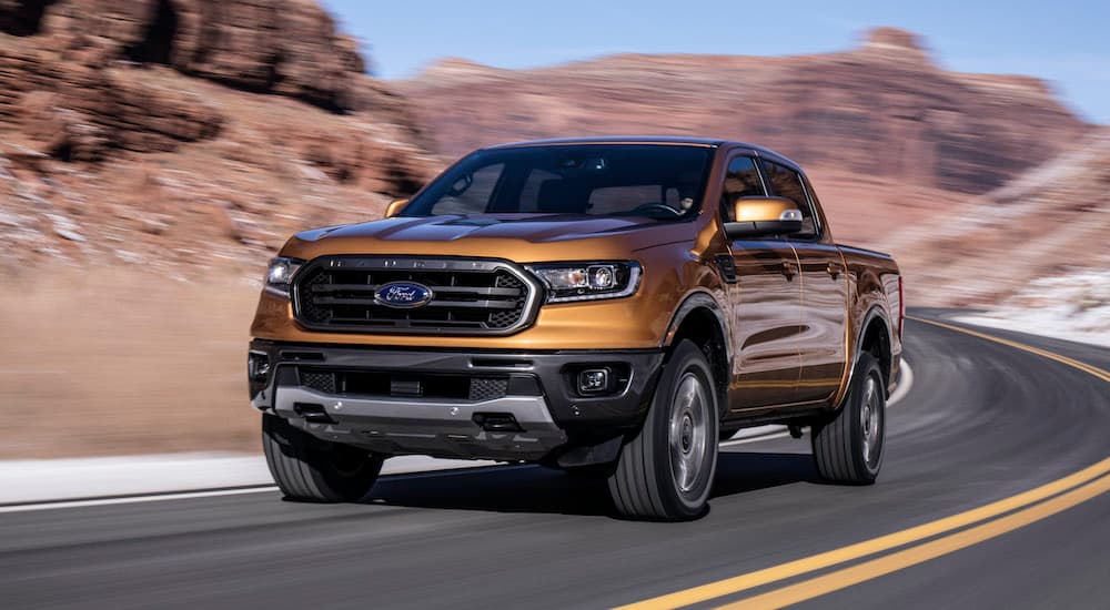 A gold 2019 Certified Pre-Owned Ford F-150 Ranger is driving on an open road in the desert. 