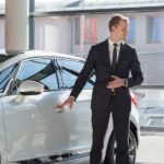 A salesmen is talking to a car buyer about the current auto news.