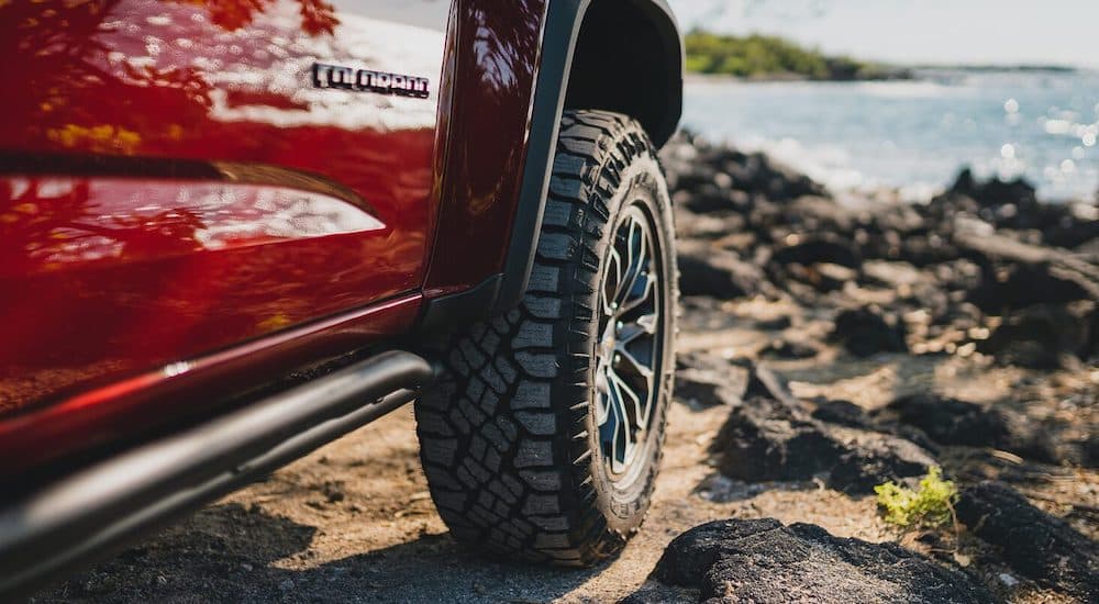 A close up shows the wheel of a 2021 Chevy Colorado ZR2 while parked on a beach.
