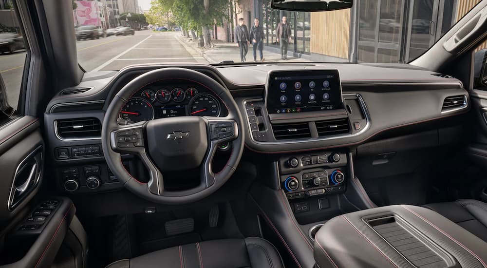 The interior of a 2021 Chevy Tahoe shows the steering wheel and infotainment screen.