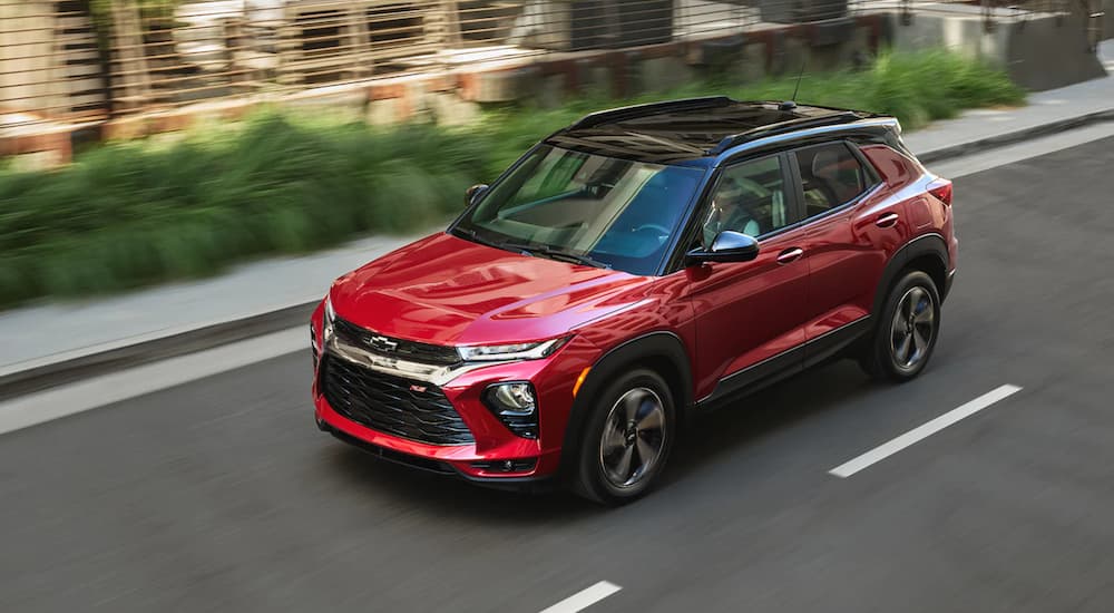 A red 2021 Chevy Trailblazer is shown driving through a city.
