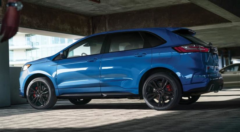 A light blue 2021 Ford Edge is shown from the side parked in a parking garage.