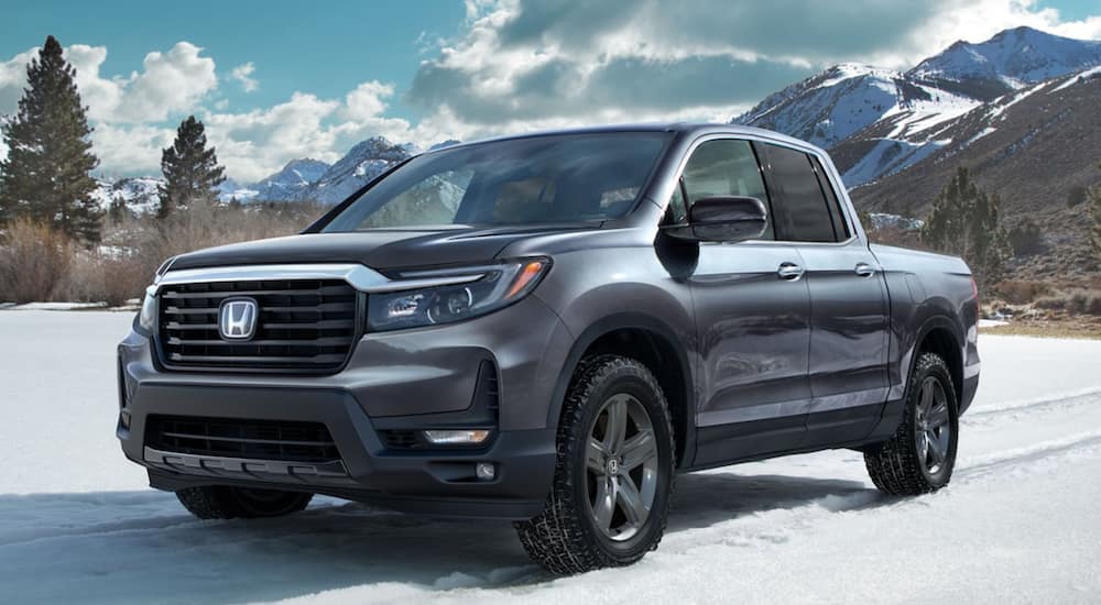 A silver 2021 Honda Ridgeline RTL-E is parked in the snow.