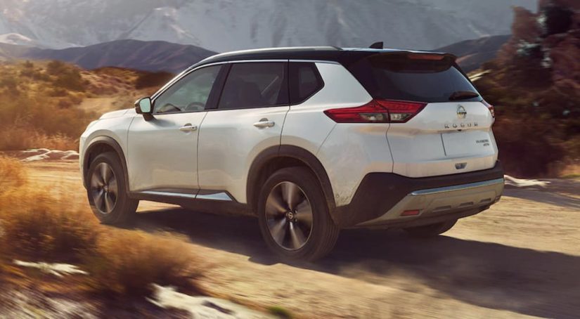 A white 2021 Nissan Rogue is off-roading in the desert.