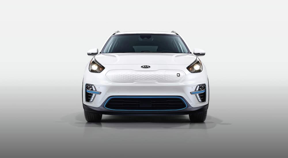 The front of a white 2020 Kia Niro EV is shown in a white room.