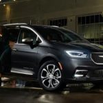 A black 2021 Pacifica Hybrid is parked as a couple gets out of the vehicle.