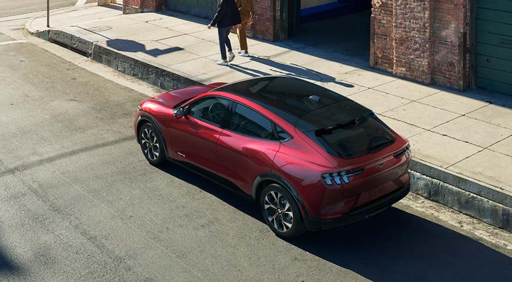 A red 2021 Ford Mustang Mach-E is shown from above parked on a city street.