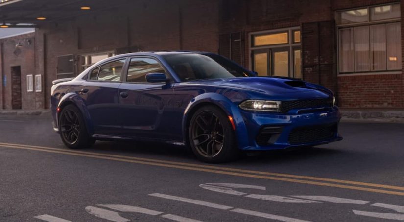A blue 2021 Dodge Charger is parked on a city street after leaving a Stellantis convention.