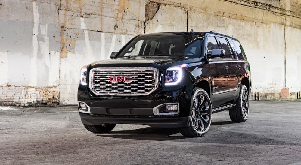 A black 2018 GMC Yukon is parked inside of a cement building after leaving a used GMC SUV dealer.