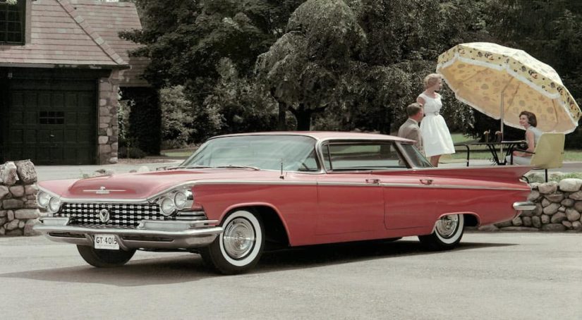 A red 1959 Buick LeSabre is parked in a driveway.