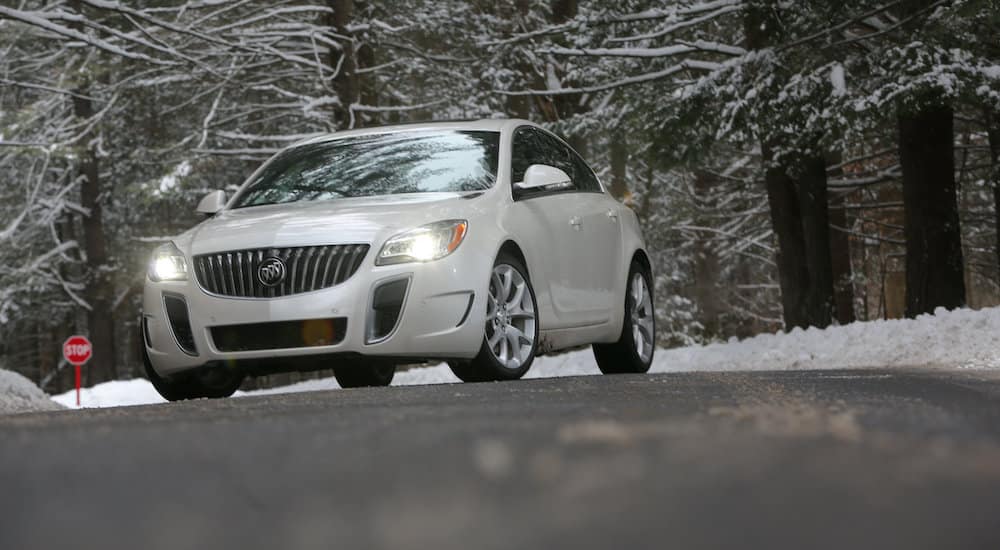 A white 2016 Buick Regal is parked on a snowy road.