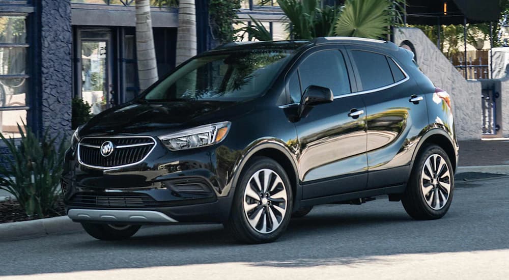 A black 2021 Buick Encore is parked on a city street.