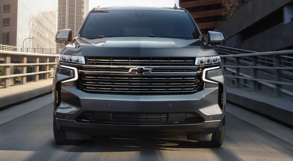The front of a black 2021 Chevy Tahoe is shown from the front driving on an off-ramp.