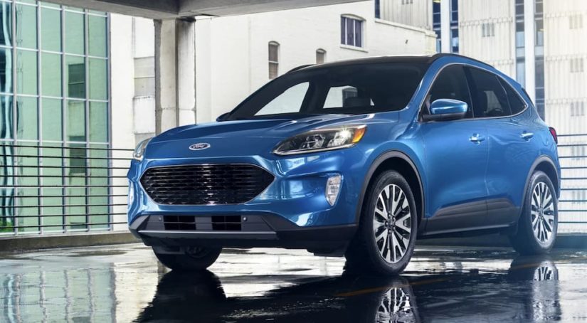 A blue 2021 Ford Escape is shown parked in a modern gallery after winning a 2021 Ford Escape vs 2021 Chevy Equinox comparison.