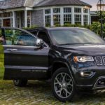 A black 2021 Jeep Grand Cherokee is parked in front of a house after winning a 2021 Jeep Grand Cherokee vs 2021 Subaru Ascent comparison.