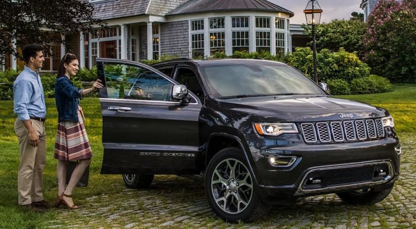A black 2021 Jeep Grand Cherokee is parked in front of a house after winning a 2021 Jeep Grand Cherokee vs 2021 Subaru Ascent comparison.