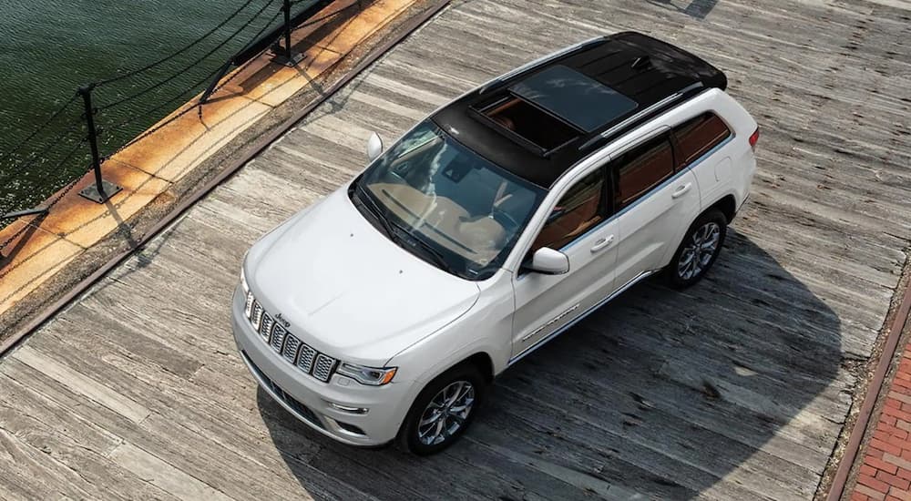 A white 2021 Jeep grand Cherokee is shown from above driving on a dock.