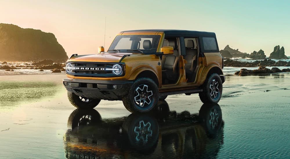 A yellow 2021 Ford Bronco Outer Banks is shown parked on the beach.