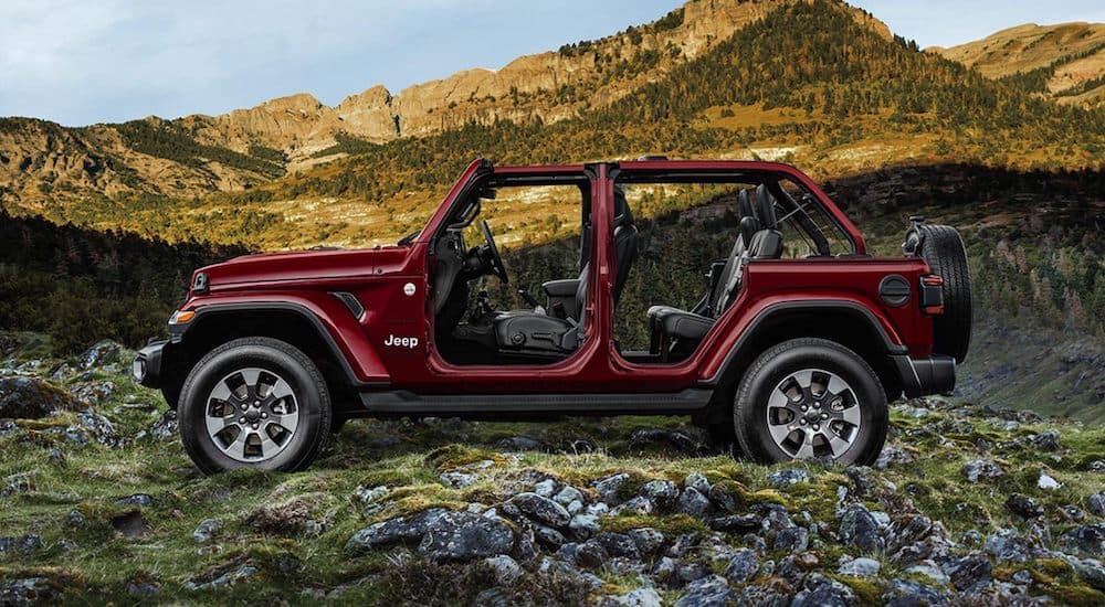A burgundy 2021 Jeep Wrangler Sahara Unlimited is shown from the side with no roof and doors.