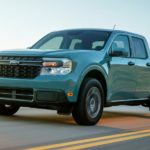 A blue 2022 Ford Maverick XLT is shown driving down an empty road.