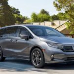 A grey 2022 Honda Odyssey Elite is parked in front of a soccer field after winning a 2022 Honda Odyssey vs 2021 Chrysler Pacifica comparison.
