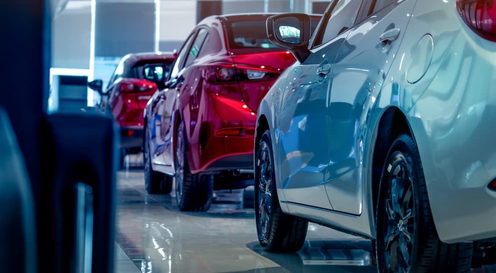 A row of cars is shown at a dealership.