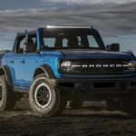 A blue 2021 Ford Bronco is parked in the desert after leaving a Ford Bronco dealership.