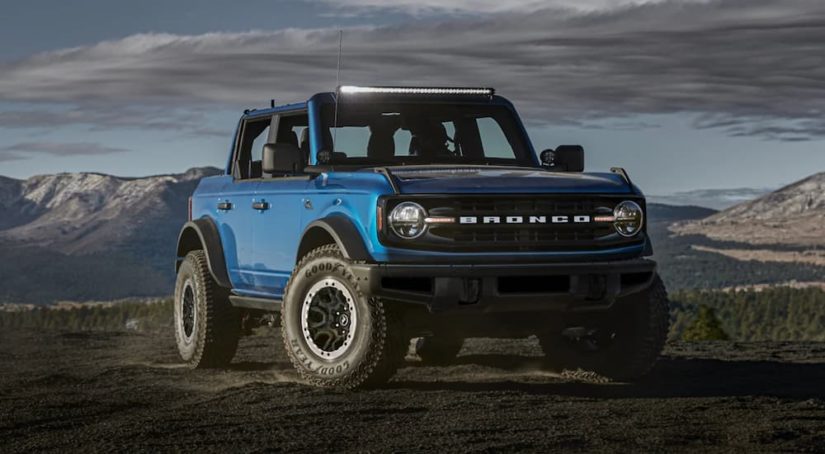 A blue 2021 Ford Bronco is parked in the desert after leaving a Ford Bronco dealership.