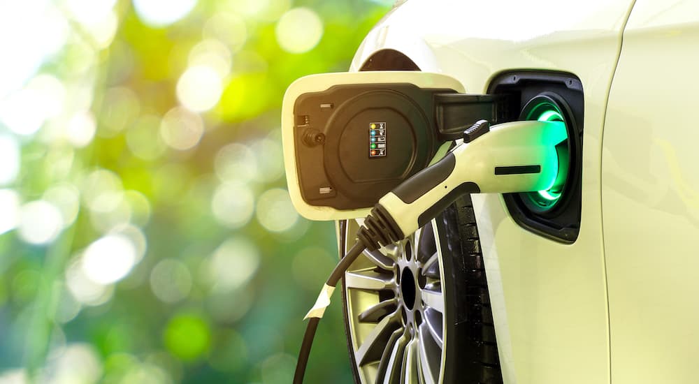 A close up shows an electric vehicle charging.