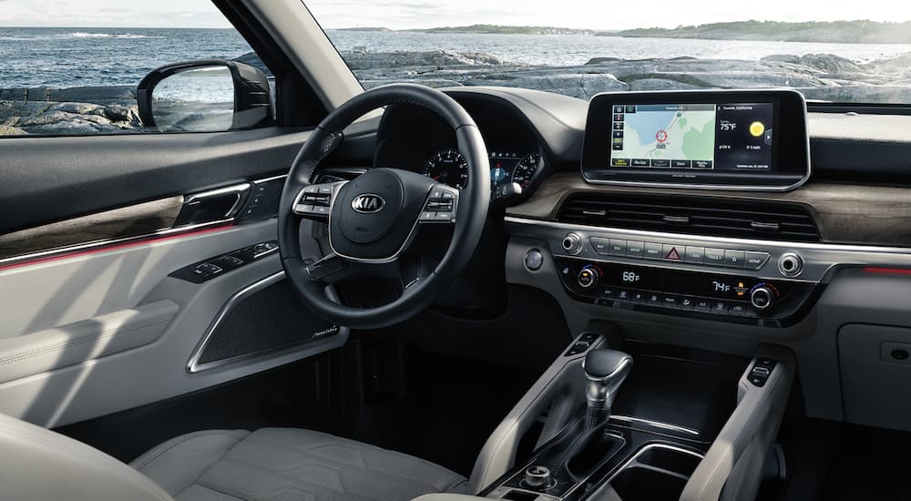 The interior of a 2021 Kia Telluride shows the steering wheel and infotainment screen.