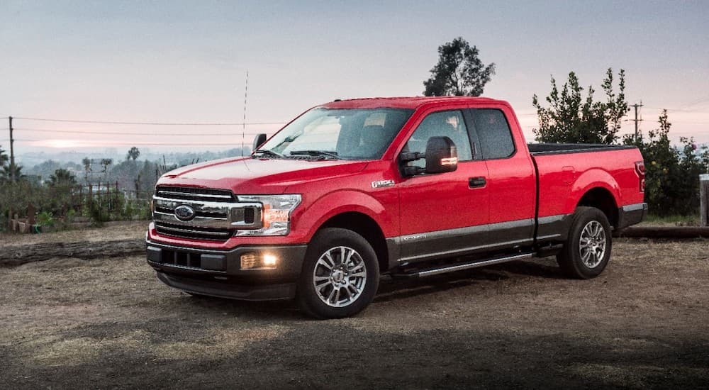 A red 2018 Ford F-150 is shown from the side parked on the dirt.