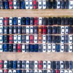 An aerial shot shows the car lot at a used car dealership.