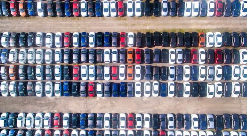 An aerial shot shows the car lot at a used car dealership.