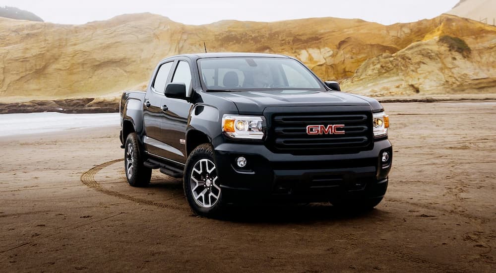 A black 2020 GMC Canyon is shown parked after leaving a used car lot.