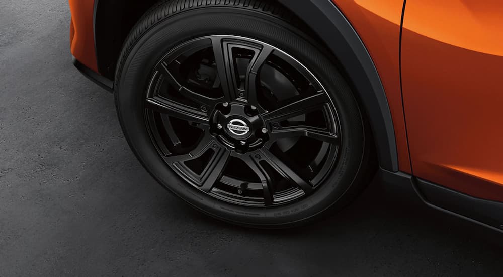 A close up shows the rear tire of an orange 2021 Nissan Kicks.