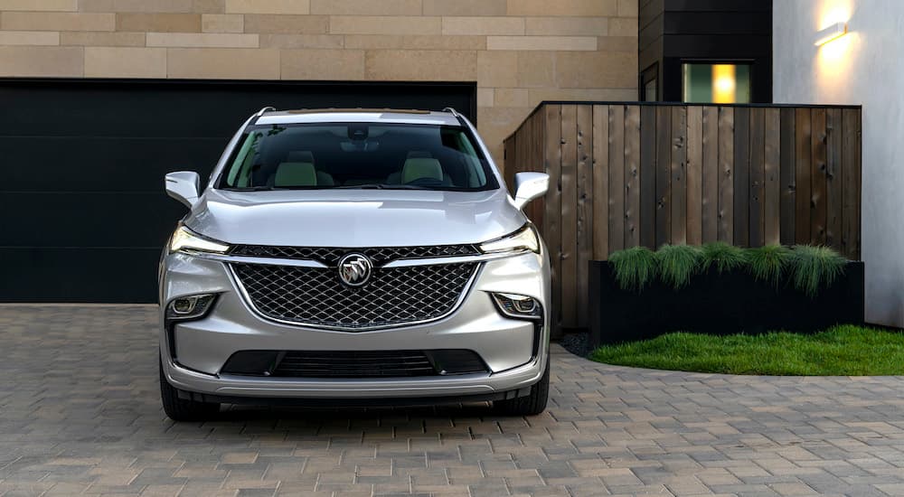 A silver 2022 Buick Enclave is shown from the front parked in a modern driveway.