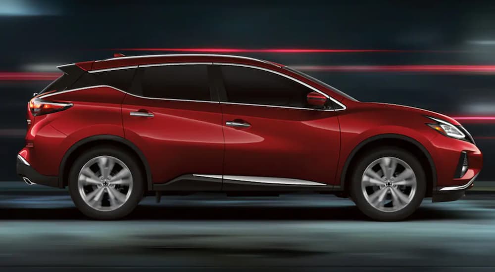 A red 2021 Nissan Murano is shown from the side driving at night.